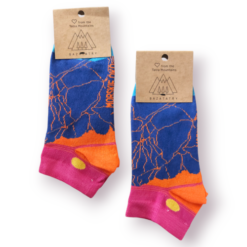 Skarpetki stopki z nowoczesną grafiką Morskiego Oka. Niebieskie szczyty, na tle różowo-pomarańczowego nieba i zachodzące słońce. Na dole tafla jeziora. Pod stopą napis Morskie Oko. Papierowa metka z logo BazaTatry.