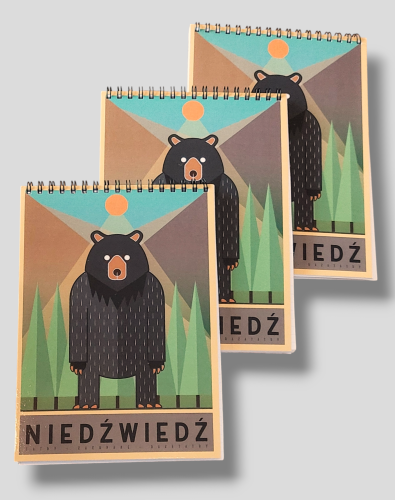 Trzy zeszysty, łączone spiralą na górze. Grafika stojącego niedźwiedzia.