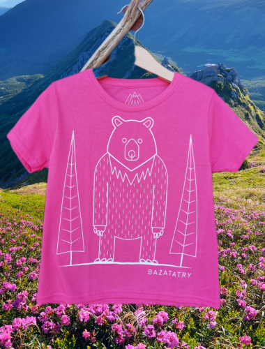 Różowa koszulka dla dzieci z krótkim rękawem. Luźny krój. Na środku nowoczesna grafika stojącego niedźwiedzia, na tle drzew iglastych. Minimalistyczna, białe linie. Na dole napis BazaTatry.