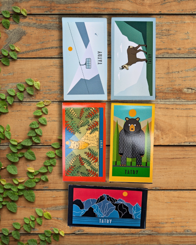Zakładki magnetyczne na drewnianym stole. Pięć wzorów, tematyka Tatry i zwierzęta tatrzańskie.