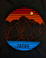 Nowoczesna grafika w formie koła. Pomarańczowe kontury szczytów, na tle czerwono-pomarańczowego nieba. Zachodzące słońce. Na dole tafla jeziora i napis Tatry.