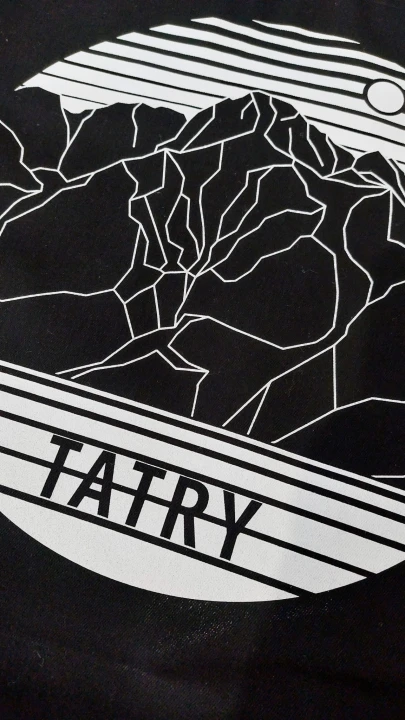 Zbliżenie na grafikę. Nowoczesna, minimalistyczna w formie białych lini. Przedstawia szczyty Tatr, na tle zachodzącego słońca. Na dole tafla jeziora i napis Tatry.